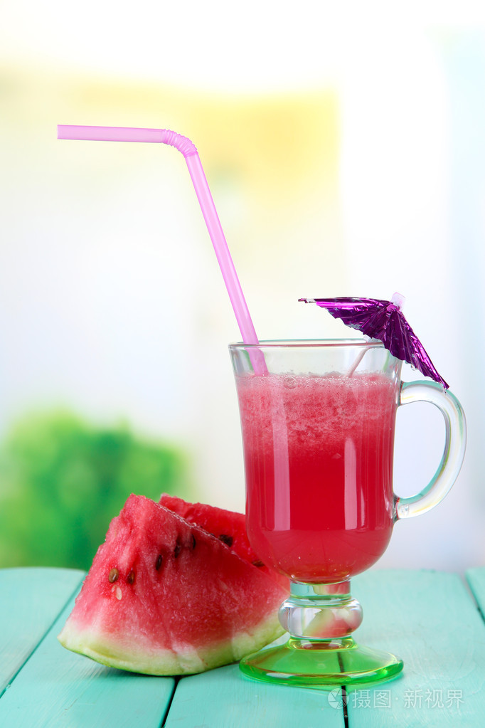 杯新鲜西瓜汁木桌上在明亮的背景上