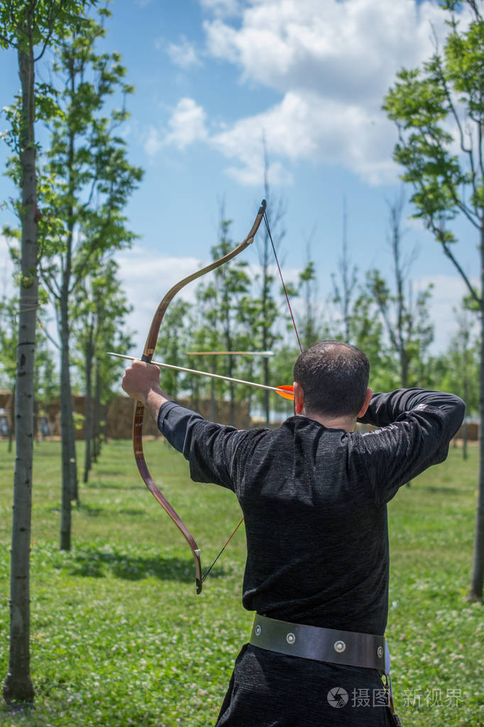 弓箭手弓在传统的衣服射击箭