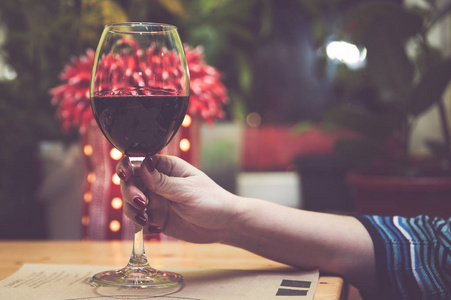 一个女孩手里拿着一杯红酒, 调子.概念女孩和酒精照片