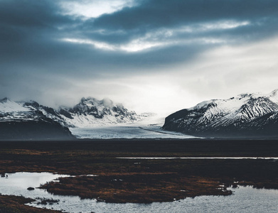 通往冰岛的巨大冰川和山脉的道路 Vatnajokull 冰川空中无人机图像与街道高速公路和云彩和蓝色天空。Vatnajokull