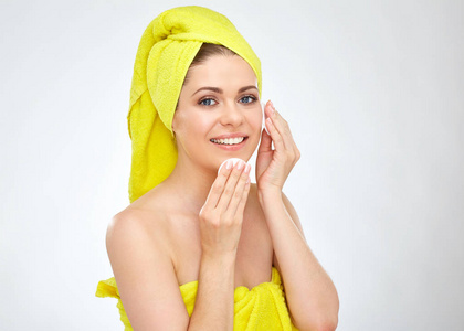 微笑妇女用毛巾在头清洁面孔皮肤用棉垫隔绝在白色背景上