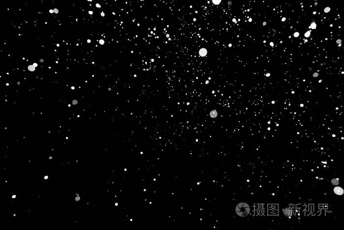 暴风雪的纹理在黑色背景上的散景灯拍摄的飞片雪花在空中