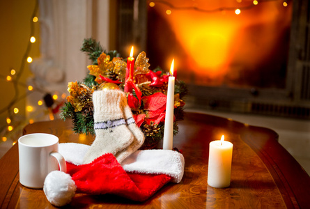 蜡烛 羊毛袜和圣诞老人的帽子，躺在桌子靠火