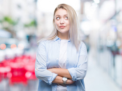 年轻的金发女人在孤立的背景微笑着看一边, 凝视着远离思考