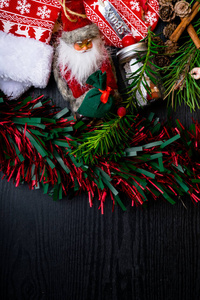 圣诞节装饰 红色圣诞老人, 丝袜, 常绿分支与松果和圣诞节玩具天使在木背景