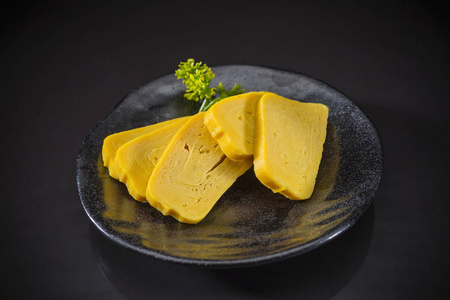 玉子生鱼片, 甜蛋供应传统日本料理的陶瓷菜, 日本料理风格, 寿司吧菜单上黑色背景, 选择性焦点
