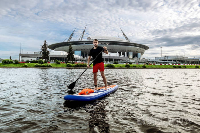 august, 在圣彼得堡体育场前, 一名男子在水面上骑着一个划桨板
