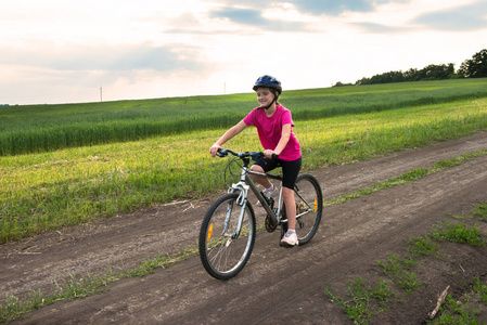 运动的女孩与自行车在绿色领域