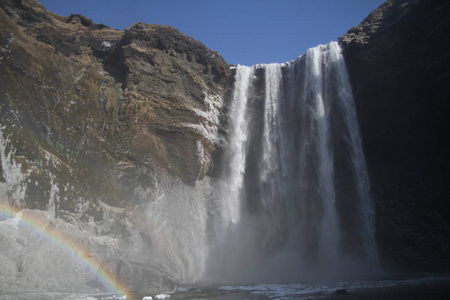 Skogafoss 瀑布在冰岛。冰岛南部冰岛自然景观的著名旅游胜地和地标目的地。冬季瀑布上的彩虹