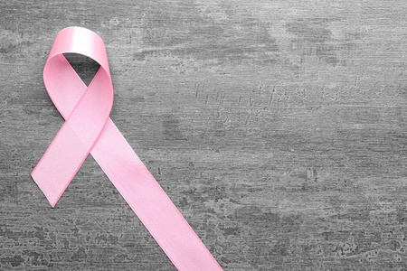 灰色背景上的粉红色丝带。乳癌概念