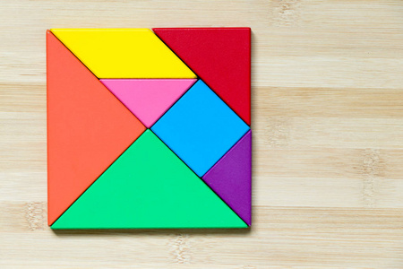 木材背景上方形形状的颜色七巧板