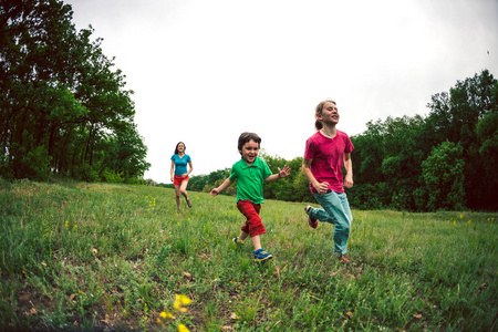 一个男孩和他的家人在户外玩耍.那孩子和他的朋友们在草地上散步.照片