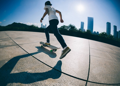 运动的年轻妇女 sakteboarding 在城市