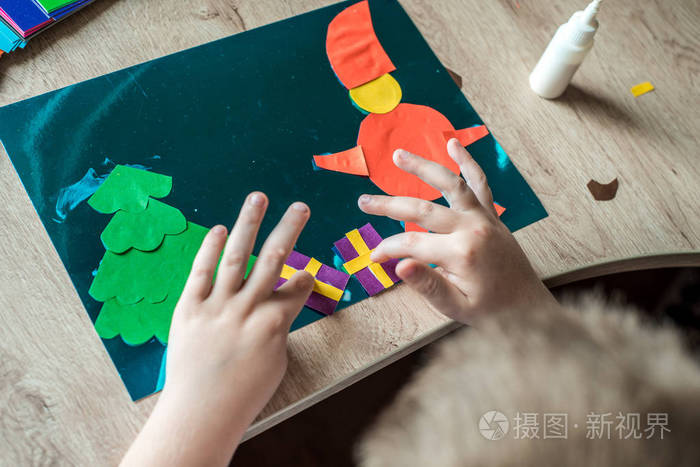 孩子手里拿着圣诞球装饰孩子正在展示圣诞球的装饰简单的回收工艺和