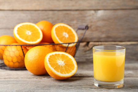 在灰色木桌上放橘子汁的杯子