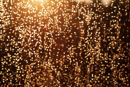 闪闪发亮的节日圣诞节灯光背景。光和黄金东富
