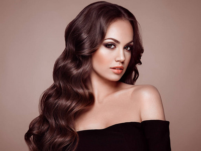 黑发女孩与长的健康和闪亮卷曲的头发.照顾和美丽.