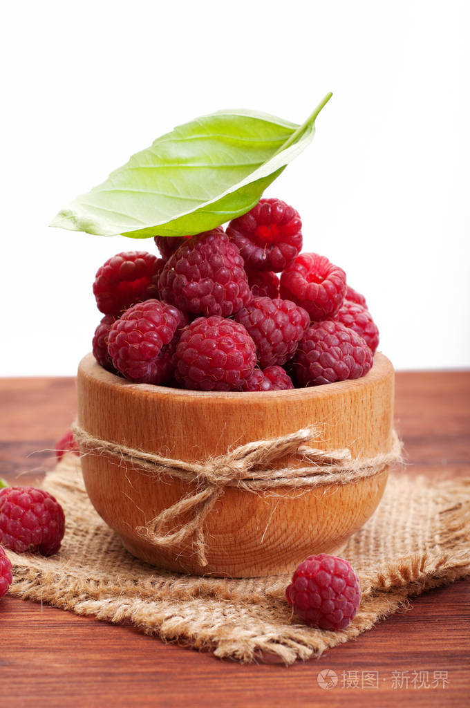 树莓在一个棕色木板板上的木板上美味的新鲜森林浆果