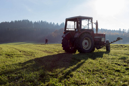 11月秋天的阳光明媚的日子里, 在德国南部农村, 在慕尼黑和斯图加特的城市附近, 老农在草丛中翻腾草