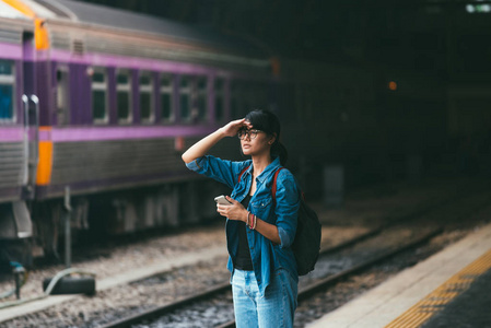 检查之旅亚洲女旅客在等候和检查列车时使用智能手机照片