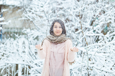 逗人喜爱的女孩玩雪在冬季森林