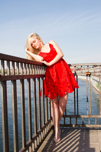 穿红衣服的女孩站在河的河堤上