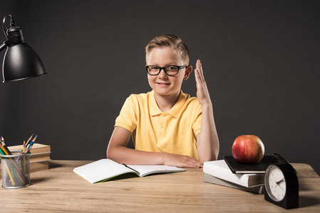 桌子上用笔记本电脑台灯钟表苹果和玻璃汁做作业的小学生的高视图孩子