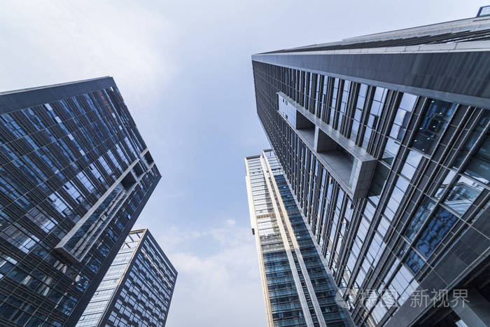 在蓝天的衬托商务区的现代摩天大楼的底视图