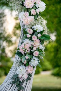 夏季户外婚礼装饰。在拱门上装饰白玫瑰绣球花和果蝇, 准备举行婚礼。垂直视图