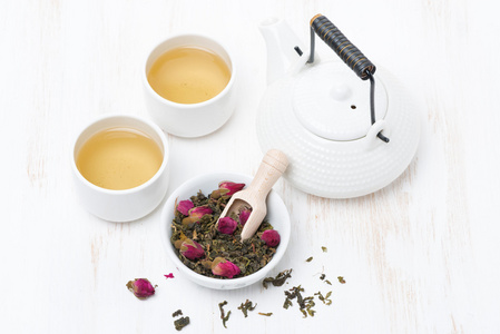 绿茶与玫瑰花蕾, 杯子, 茶壶白色桌上照片