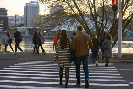 人们从后面穿过马路到禁止交通信号灯.街上的危险情况照片
