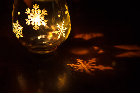 玻璃烛台与圣诞节图形在玻璃的形式。雪花, 圣诞树在黄色光中的装饰烛台中发光。节日圣诞装饰
