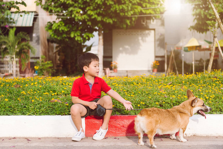 孩子亲切地拥抱著他的宠物狗，彭布罗克威尔士矮脚狗