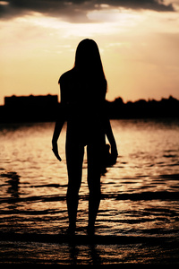 女人在日落海滩上构成的轮廓