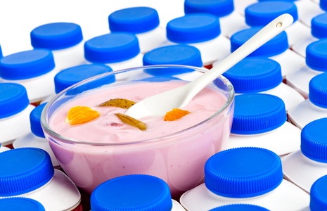 酸奶瓶用暗蓝色盖子和一个玻璃碗，用 yogur 数目