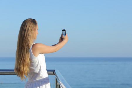 制作一张照片的大海与智能手机的女人