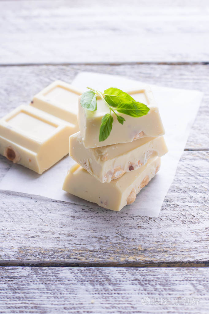 白色巧克力与坚果在白色木背景复制空间