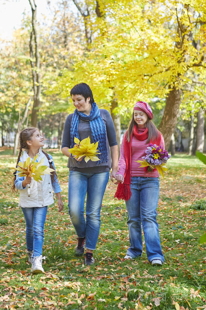 幸福的家庭.母亲和两个女儿在秋季公园.