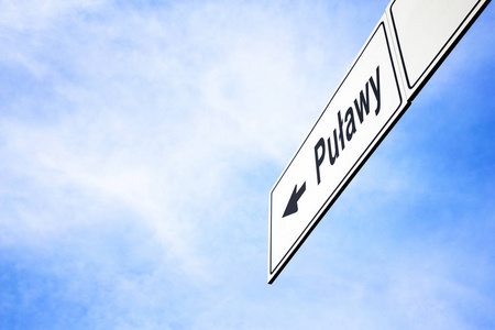 白色招牌, 箭头指向 Pulawy, 波兰, 在一个朦胧的蓝天在旅行, 导航和方向的概念。招牌包含的路径