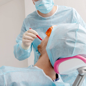 牙医医生治疗男性病人的牙齿图片