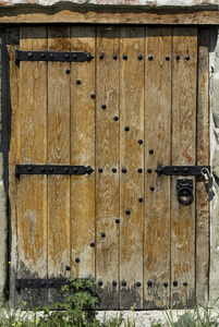 旧木门在石墙与挂锁。建筑师纹理背景