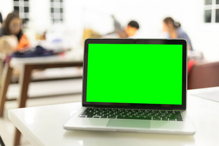 工作场所与笔记本电脑舒适的工作表在办公室, 绿色屏幕上的笔记本电脑
