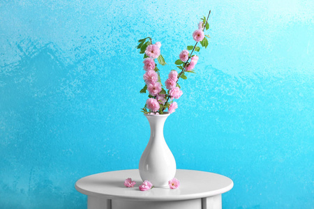 桌上有花枝的花瓶反对颜色背景