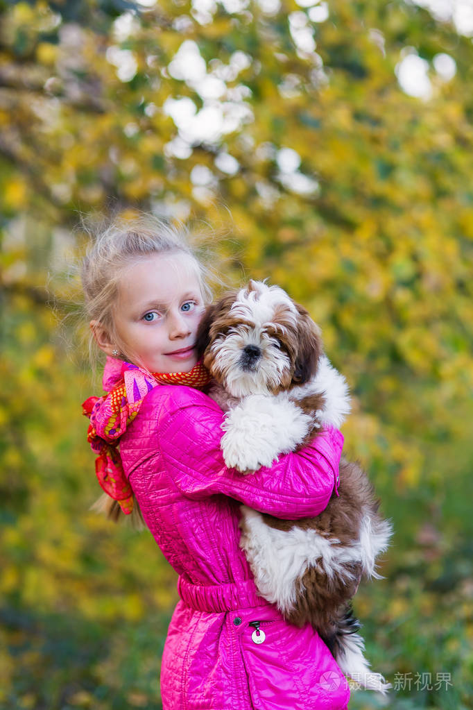 可爱的女孩拥抱小狗石慈