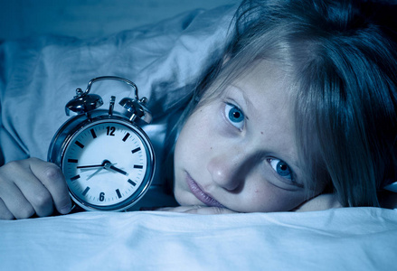累趴下可爱可爱的不眠之夜的小女孩在床上醒着, 在半夜看起来很累