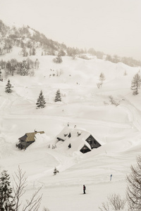 冬季景观与一位滑雪者和一间木屋在山上
