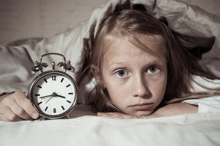 累趴下可爱可爱的不眠之夜的小女孩在床上醒着, 在半夜看起来很累
