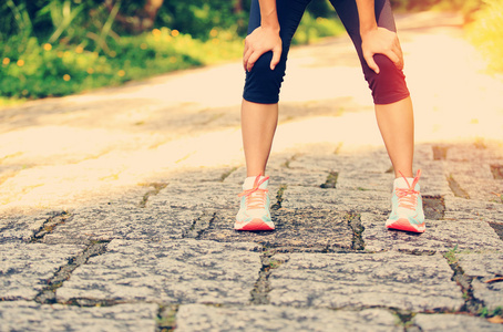 运动出汗累了的女子赛跑运动员,休息后运行硬在乡村的道路.