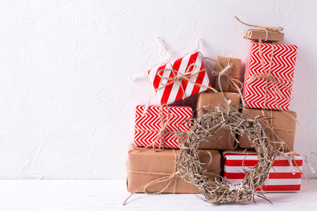 五颜六色的包装礼品盒与礼物和装饰花圈在白色纹理背景。选择性对焦。文本位置