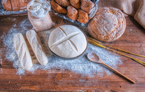 面包和面粉在一个质朴的木桌上。面包店和食品杂货店概念